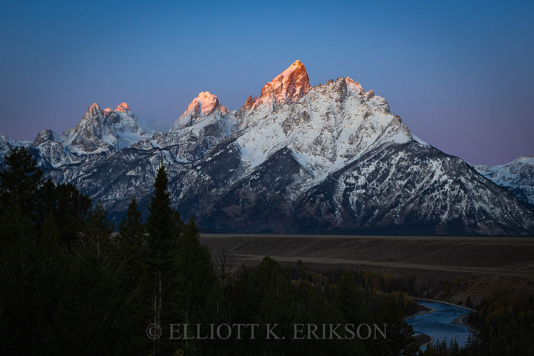 New Day Dawning - Grand Tetons. Pink and purple hues of morning sunlight on snowy Grand Tetons.