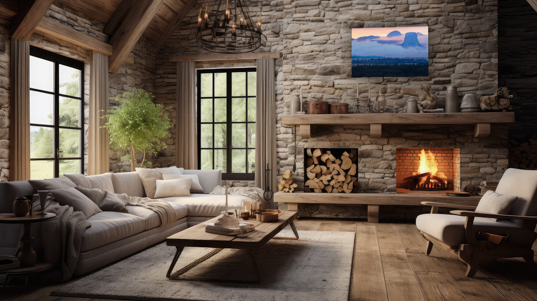 Cozy living room with stone fireplace, large sectional sofa, and a photography print of Devils Tower