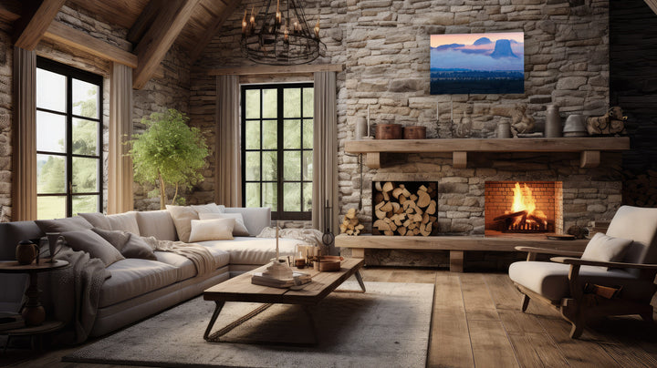 Cozy living room with stone fireplace, large sectional sofa, and a photography print of Devils Tower